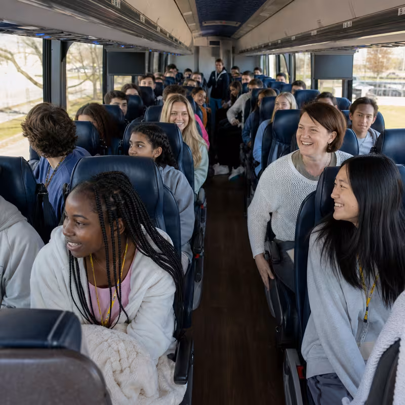 Group boarding a white charter bus for School Transportation transportation in Washington
